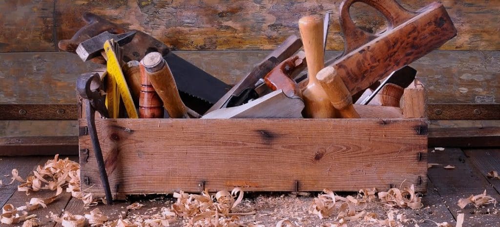 Old wooden toolbox filled with hand tools.