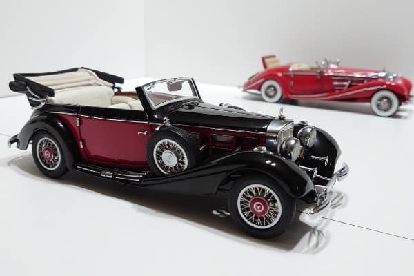 A black-and-red Mercedes roadster in 1/24 scale with another red Mercedes model in the background.